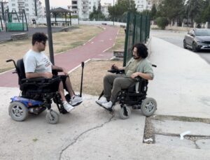 Osmaniye Kadirli’de Furkan Ulusoy, engelliler için arkadaşıyla akülü sandalyede gezdi