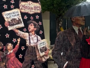 Yağmurda Atatürk maketini şemsiyeyle korudu